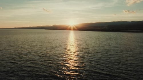 Silhouette of Mountains and Sun in Front of an Ocean Expanse at Sunset Wedding