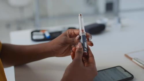 Woman with Diabetes Studying Insulin Pen during GP Visit