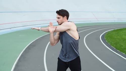Fit Man Exercising Before Workout at Sport Stadium. Handsome Male Runner Warming