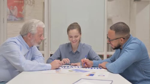 Young Woman Doing Paperwork with Team