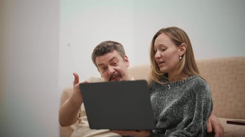 Happy Couple Video Calling with Friends on a Laptop