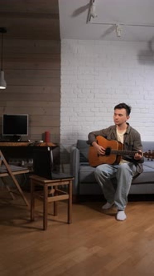 Man Plays Acoustic Guitar in Living Room