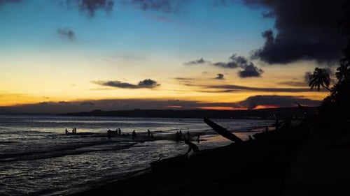 Silhouette, men pulling out fishing net from ocean beach during sunset. Vietnam
