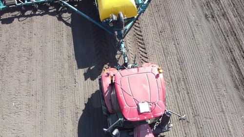 Tracteur avec semoir jaune travaillant sur le terrain en Ukraine OA Lexa