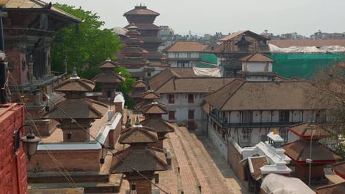 Cinematic trucking pan across Kathmandu alleyway leading to homes and shrine altars