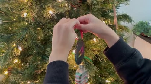 De petites mains installent une décoration de Noël faite main en 2020.