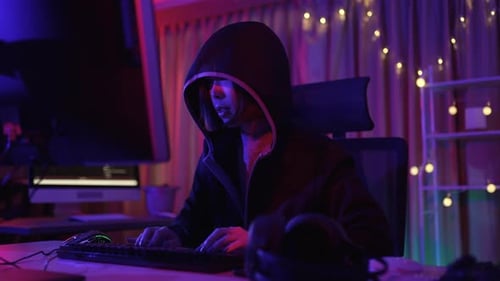 Young Adult Typing at Computer in Dark Room