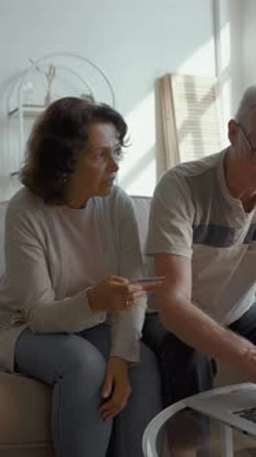 Mature Couple Using Laptop in Bright Home