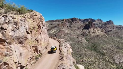 Aerial View of SUV driving on a Narrow Road on the Edge of a High Cliff. Apache Trail in Arizona, St