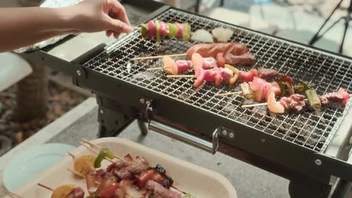 Hands of Unrecognizable Person Putting Skewers on Outdoor Grill