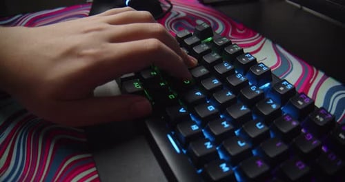 крупный план рук на механической клавиатуре с подсветкой