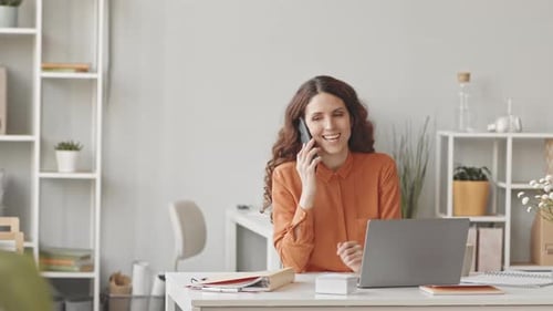 Young Businesswoman Talking on Mobile Phone in Office