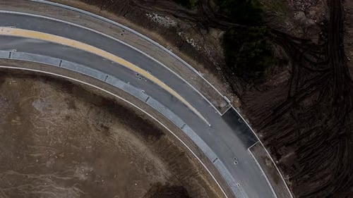 Curved road under construction with exposed earth