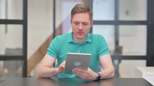 Stressed Man Using Tablet in Office Setting