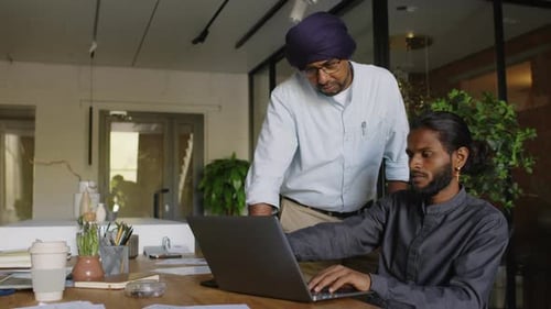 Indian Young Employee Showing Work Result to Boss on Laptop in Office