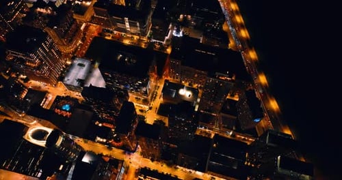 Moving over the tops of the high-rise buildings in downtown at night.