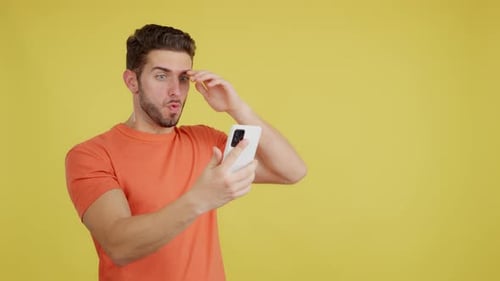 Surprised Young Adult Reacts to Mobile Phone Content