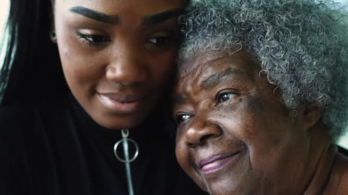 Affectionate Young Woman Hugs Senior Woman Indoors