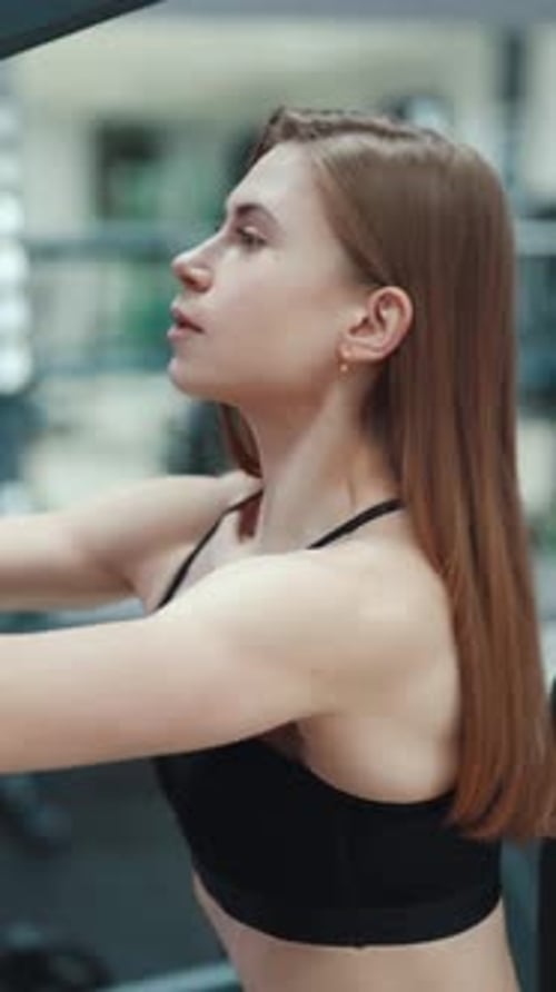 Young Woman Working Out at the Gym on Machine