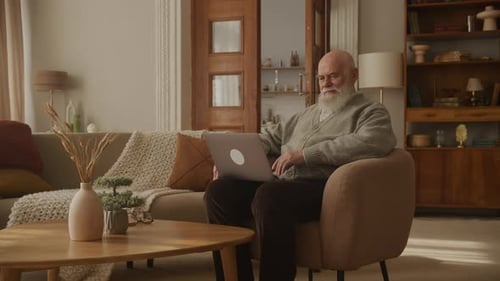 Elderly Man Using Laptop in Cozy Living Room