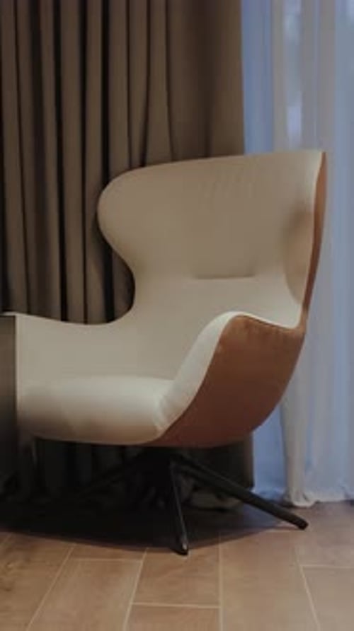 Egg Chair Sits Near Curtain Indoors