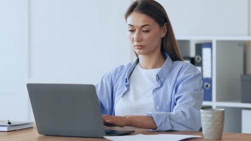 Female Secretary Typing Financial Report on Laptop at Home