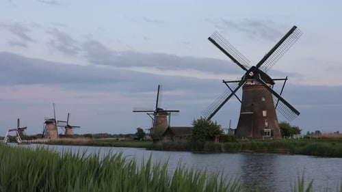 Beautiful wooden windmills at sunset in the Dutch village of Kinderdijk. Windmills run on the wind.