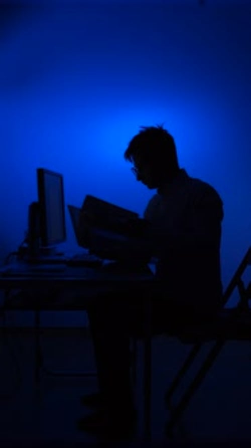 Vertical Video Person Working Late Night in Blue Light Environment