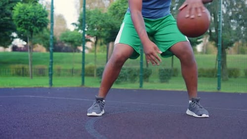Closeup of African American Male Basketball Player Training on Outdoor Court