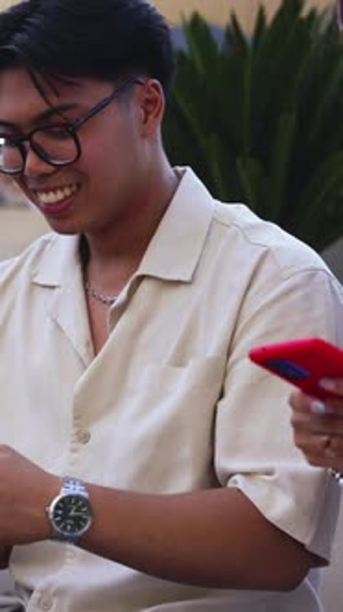 Group of friends sit together looking at phones