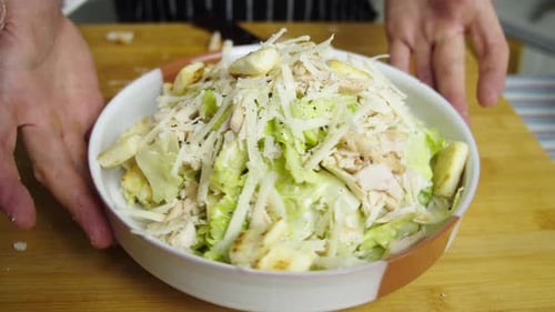 Chef rotates plate with caesar salad. Close up slow motion shot. Plating caesar salad dish.