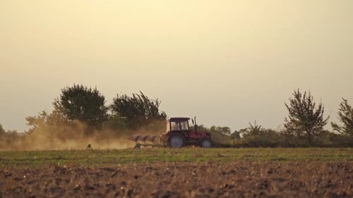 Tractor in the field in rural place. Agricultural machinery on the soil during seasonal works.