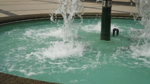 Water flows at high speed and pressure out of a water feature fountain in a public square in Vancouv