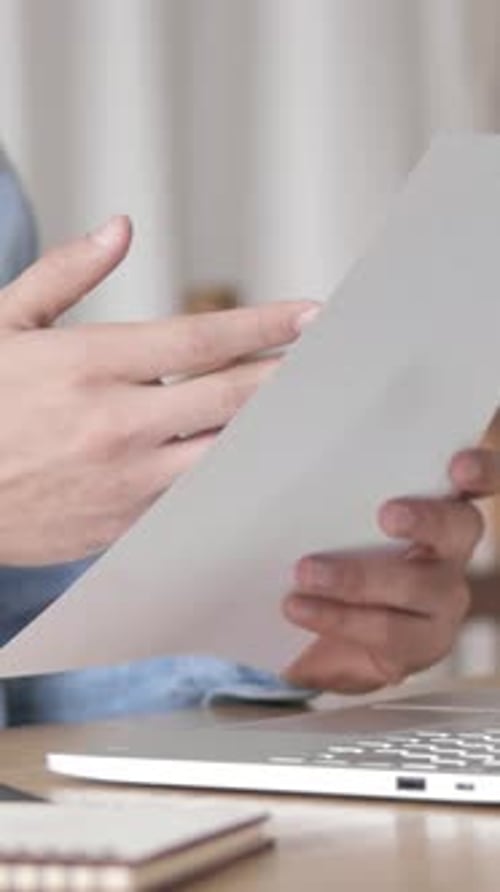 Man Crushing Paper in Frustration at Desk