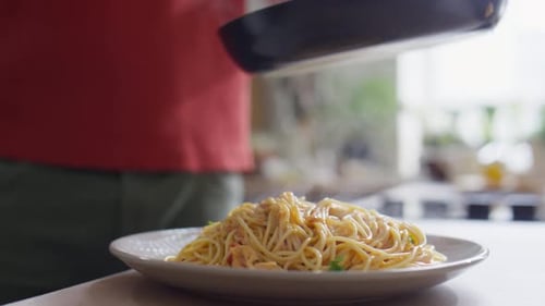 Chef Plates Steaming Pasta with Tongs at Home