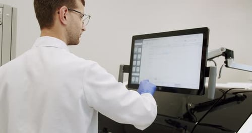Scientist Interacting With Touchscreen Computer in Lab