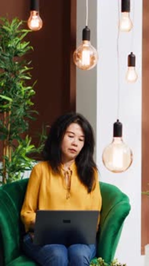 Woman Working On Laptop In Green Chair