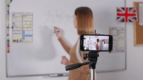 Teacher Writes on Whiteboard During Recorded Class