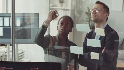Colleagues Brainstorming Ideas Using Sticky Notes in Office