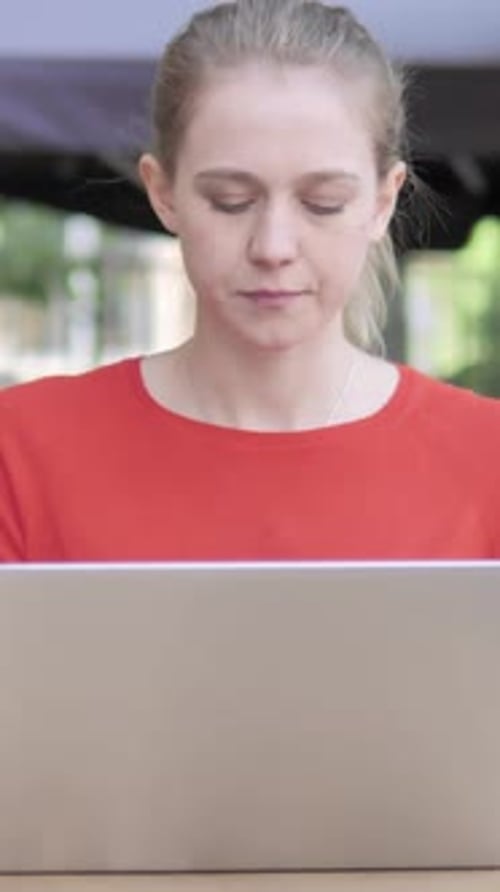 Young Woman with Headache Using Laptop Sitting in Cafe Terrace, Vertical Video
