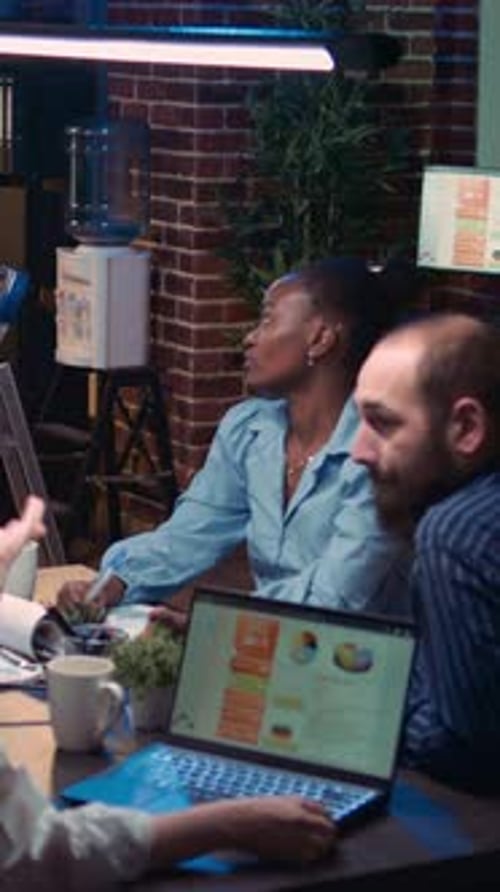 Team Collaborates Over Data at Night in Office