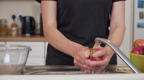 Rincer une pomme entière sous le robinet, préparer une compote maison, laver les fruits frais, nettoyer la surface