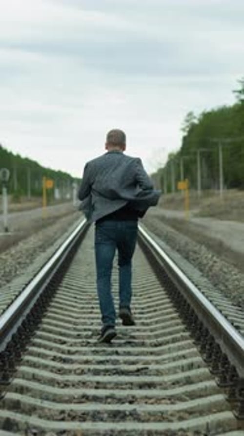 Man Running Down Rural Railroad Tracks