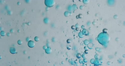 Slow motion macro of blue micro particles molecules in a liquid are analyzed with microscope for r