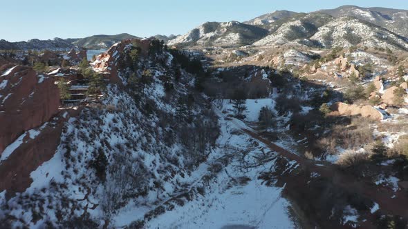 Aerial dolly forward next to red rock ridge covered in snow, Nature ...