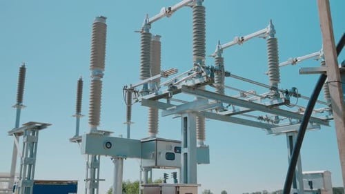 Isolatoren und elektrische Geräte für Hochspannungsstationen vor blauem Himmel