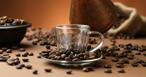 Pouring hot coffee from cezve into cup on brown background, closeup