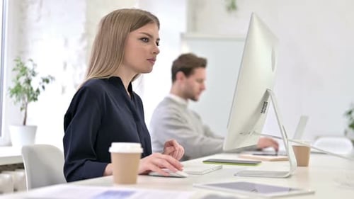 Woman Working on Desktop Computer in Bright Office