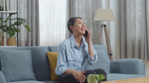Cheerful Woman Talking on Cellphone on Couch