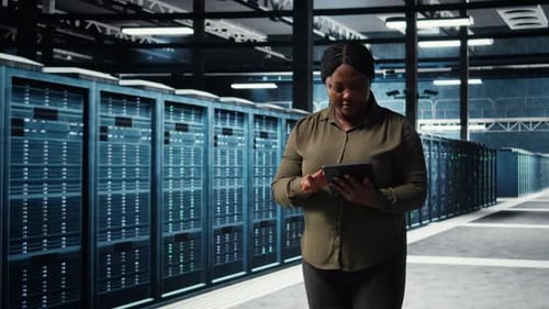 Woman with Tablet Walking in Server Room